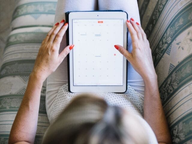 woman-watching-tablet-while-chilling-sofa