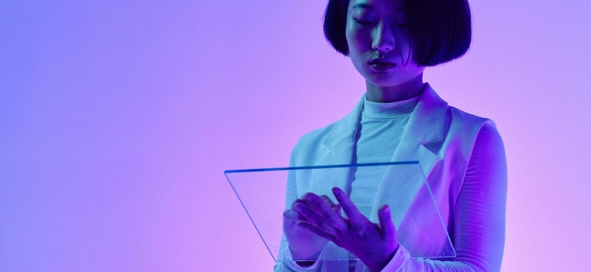 A woman works with a screen technology in a purple-lit room.