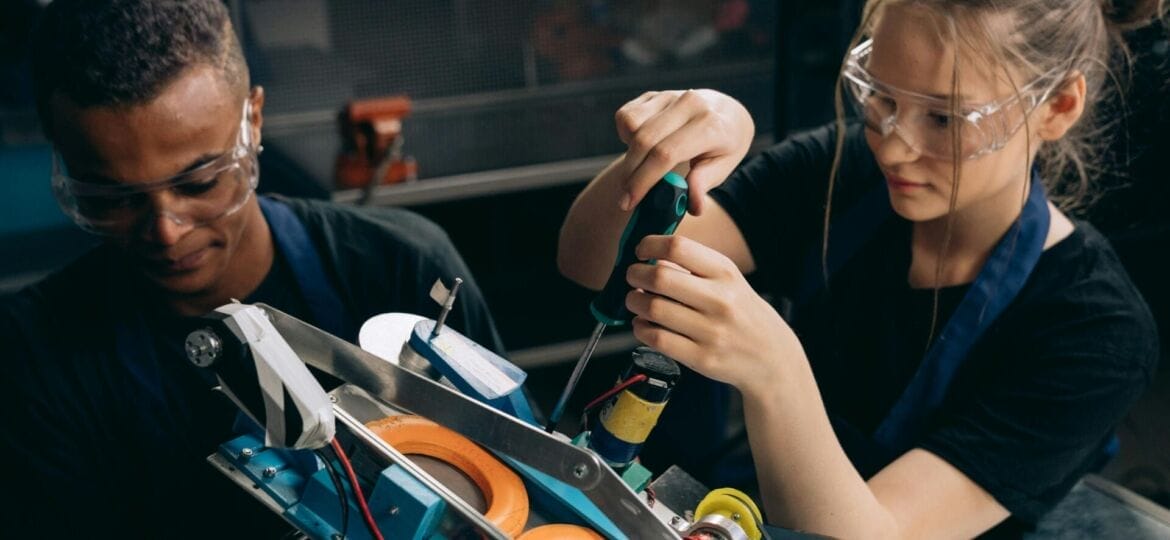 Two employees work on a manufacturing project. (Photo by: Mikhail Nilov).